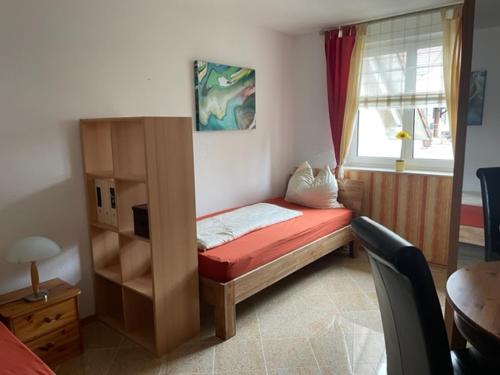 um pequeno quarto com uma cama e uma janela em Großzügige 3-Zimmer Wohnung em Rümmingen