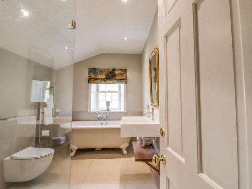 a bathroom with a tub and a sink and a toilet at Hilltop House in Starbotton