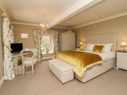 a bedroom with a bed and a desk and a computer at Hilltop House in Starbotton