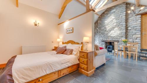 a bedroom with a large bed and a stone wall at The Stable, Llanmadoc in Llanmadoc