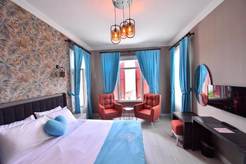 sypialnia z łóżkiem i 2 czerwonymi krzesłami w obiekcie Noya Köşk Otel w mieście Adalar