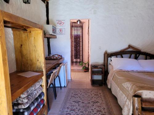a bedroom with a bed and a table in a room at Sitio Vale Piemonte "Chalés " in Santo Antônio do Pinhal