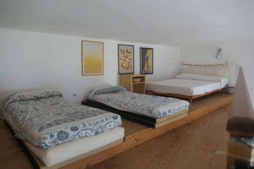 een kamer met drie bedden op een houten platform bij Loft Bellevue - Seaview - WiFi in Menton