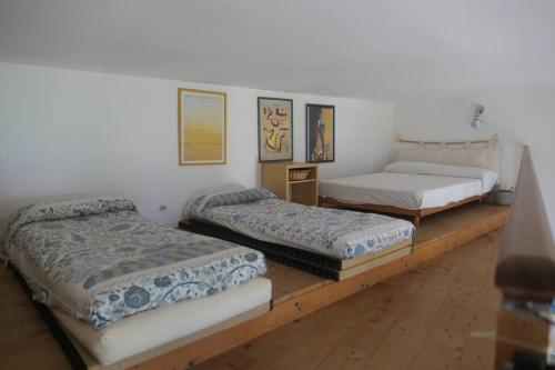 une chambre avec trois lits sur une estrade en bois dans l'établissement Loft Bellevue - Seaview - WiFi, à Menton