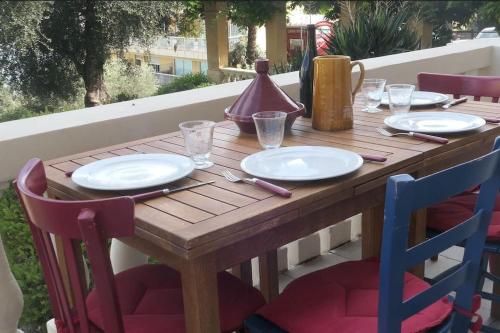 une table en bois avec des assiettes et des ustensiles dessus dans l'établissement Loft Bellevue - Seaview - WiFi, à Menton