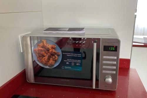 a toaster oven with a plate of chicken in it at VIVEIRO.CELEIRO. CASA TRANQUILA. RESURRECTION FEST in Cillero