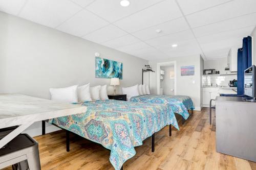 a bedroom with two beds and a kitchen at Abellona Inn & Suites in Old Orchard Beach