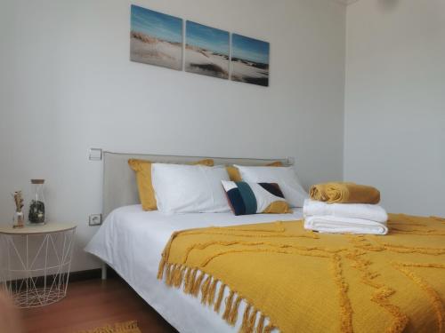 een slaapkamer met een bed met een gele deken bij Ana Paula House in Aveiro