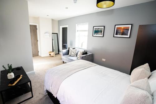 a bedroom with a white bed and a couch at Church Street Apartments in Hartlepool