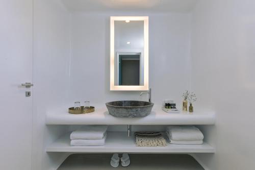 a bathroom with a sink and a mirror at Mykonos Blanc - Preferred Hotels & Resorts in Ornos