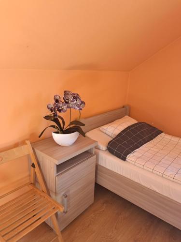een slaapkamer met een bed en een plant op een nachtkastje bij Ogrodowe Noclegi 