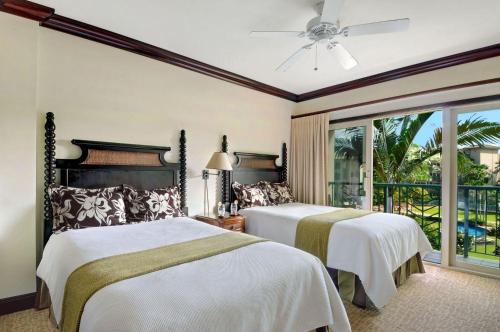 a bedroom with two beds and a balcony at Waipouli Beach Resort Gorgeous Luxury Ocean View Condo! Sleeps 8! in Kapaa