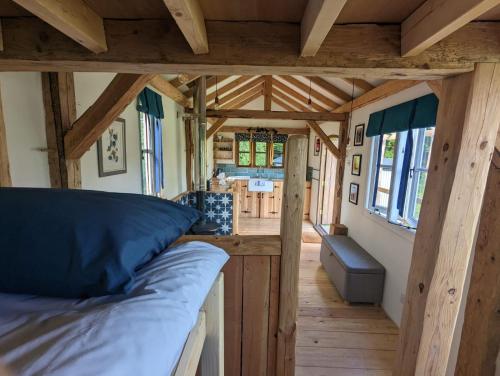 a room with a bed in a tiny house at Gaggle of Geese Pub - Shepherd Huts & Bell Tents in Dorchester