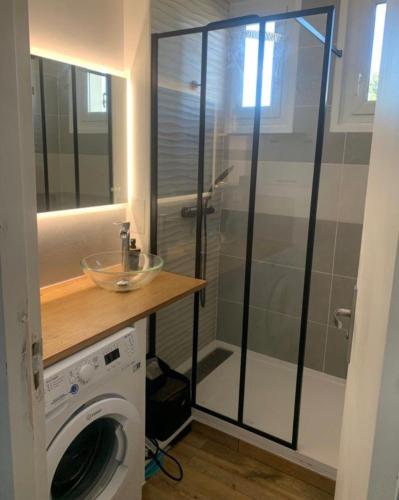 - pralkę w łazience z przeszkloną kabiną prysznicową w obiekcie Chambre 2 personnes 24h du Mans w mieście Le Mans