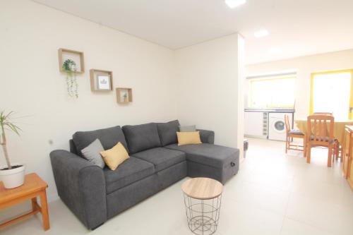 a living room with a gray couch and a table at Casa3_Praia_Beach_House in Portimão