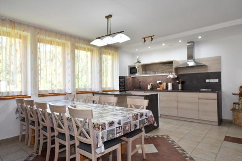 a kitchen with a dining room table and chairs at Penzión Pod Guglom in Mlynky 