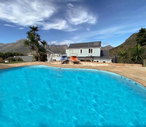 a large blue swimming pool in front of a house at Villa Amanzi in Hout Bay