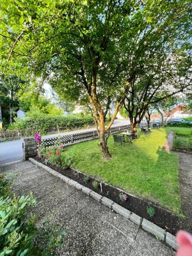 a park with a tree and benches and flowers at Pension DonauBlick Grein 1 , Spitzfeldstr 1 in Grein
