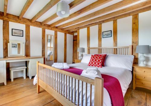 a bedroom with a bed and a desk at Stone Cottage in Darsham