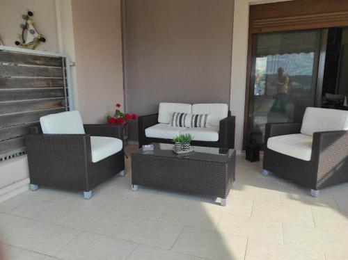 a living room with wicker chairs and a coffee table at Villa La Bella Vista in Skála Foúrkas