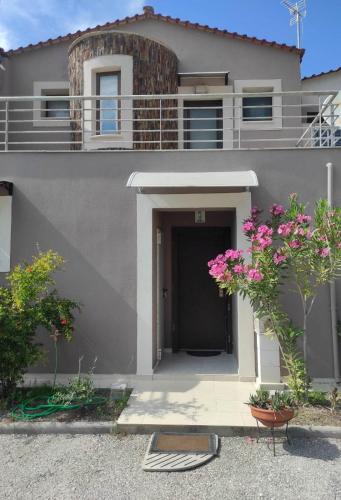 a gray house with flowers in front of it at Villa La Bella Vista in Skála Foúrkas
