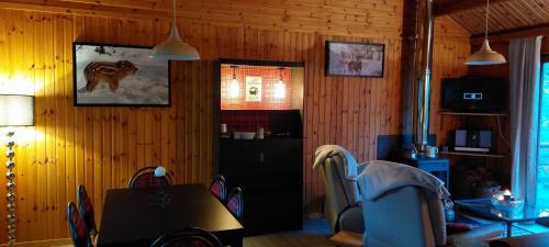 索姆勒茲的住宿－L'Ard'Heure D'Avance，一间带桌子和木墙的用餐室