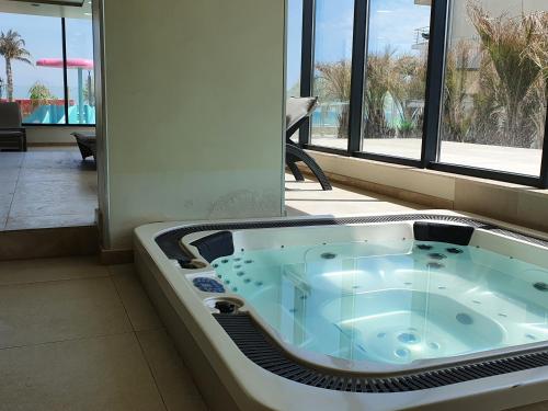 a jacuzzi tub in a room with a pool at Silverbay - Indoor Pool & Spa Resort in Mamaia Nord