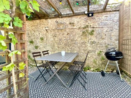 a picnic table and two chairs in an outdoor area at Les Régniers - 2 gîtes pour partir ensemble in Eynesse