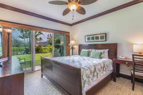 a bedroom with a bed and a desk and a window at Waipouli Beach Resort Exquisite Luxury Garden View Large Yard Perfect for Families! in Kapaa