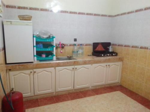 a kitchen counter with a sink and a refrigerator at Apartments in Attaouia Wonderful in Attaouiya ech Chaïbiya