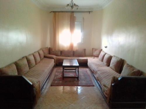 a living room with a couch and a table at Apartments in Attaouia Wonderful in Attaouiya ech Chaïbiya