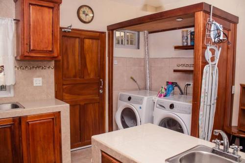 a kitchen with a washing machine and a sink at Cozy Downtown Boquete Chalet in Bajo Boquete