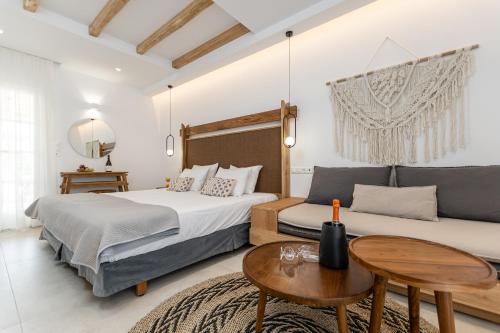 1 dormitorio con 2 camas, mesa y sofá en Spiros, en Naxos Chora