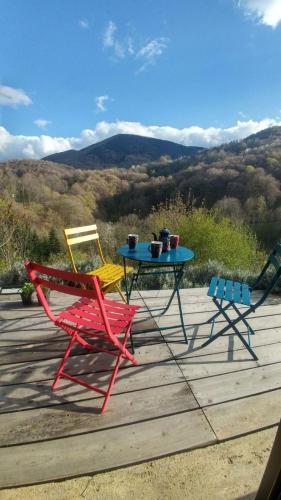 two chairs and a table on a deck with a view at The Enchanted Observatory in Ariège Pyrenees - L'observatoire enchanté des Pyrénées Ariégoises in Biert