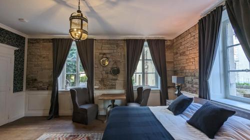 1 dormitorio con 1 cama, escritorio y ventanas en Manoir La Cerise, en Fougerolles