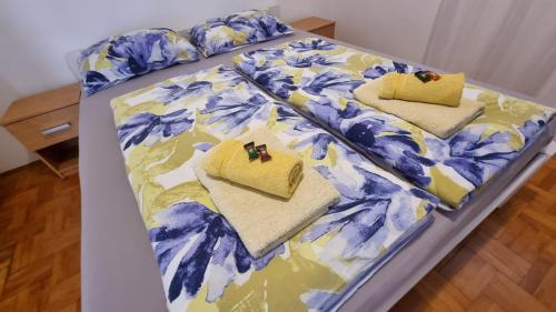 Cama con manta y almohadas azules y amarillas en Guest House Jasmin, en Rovinj