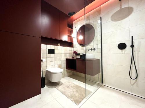 La salle de bains est pourvue de toilettes et d'une douche en verre. dans l'établissement WYSZYŃSKIEGO Apartment - Self Check-In 20h - Parking &Lift, à Wrocław