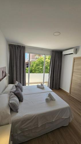 a large bed in a room with a large window at Apartamento Trajano in Santiponce