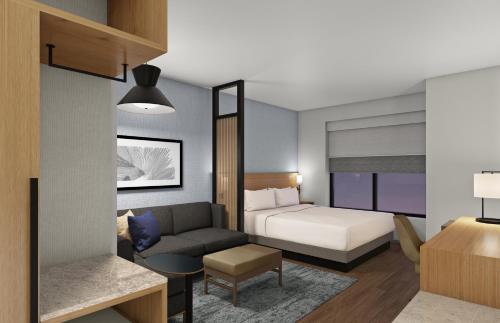 a hotel room with a bed and a couch at Hyatt Place Boise-Meridian in Meridian