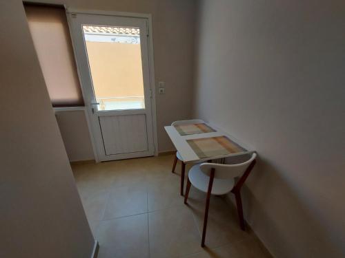 a table and a chair in a room with a window at K & A Studios 1 in Nydri