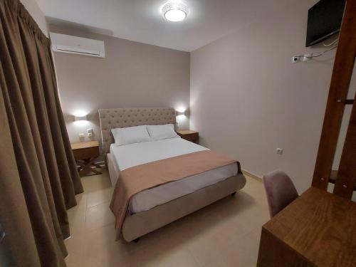 a bedroom with a bed and a desk and a chair at K & A Studios 1 in Nydri