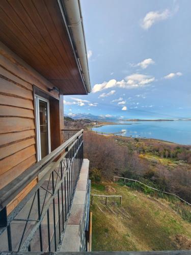 a balcony of a house with a view of the water at Mirabeagle Departamentos in Ushuaia