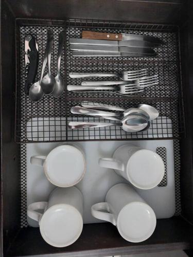 a drawer filled with white dishes and utensils at Villas Cozumel #8 in Cozumel