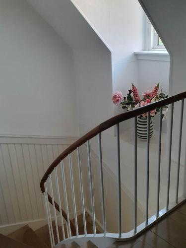 a stairway with a vase with flowers in it at Pegasus Bed & Breakfast in Hillerød