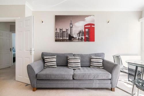 uma sala de estar com um sofá cinzento e uma cabina telefónica vermelha em Spacious Home- Great transport links and location- Families- contractors- professionals em Watford