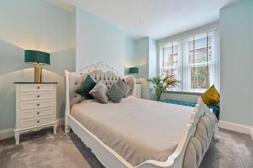 ein Schlafzimmer mit einem weißen Bett und einem Fenster in der Unterkunft Wembley Luxury Residence- Opulence House in London