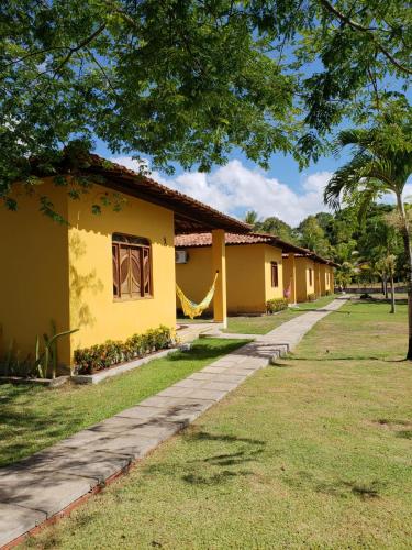 a row of houses with yellow paint at Pousada Pratigi in Ituberá