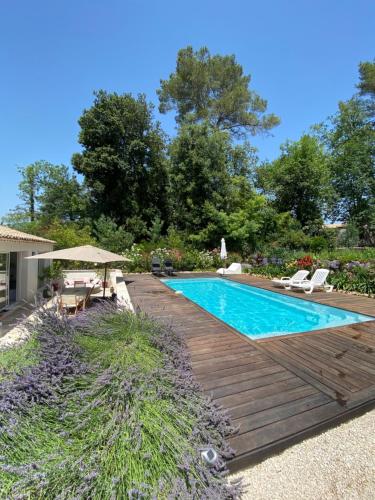 - une piscine avec une terrasse en bois à côté d'une maison dans l'établissement Villa OHA close Cannes,Nice, Valbonne , Opio, à Roquefort-les-Pins