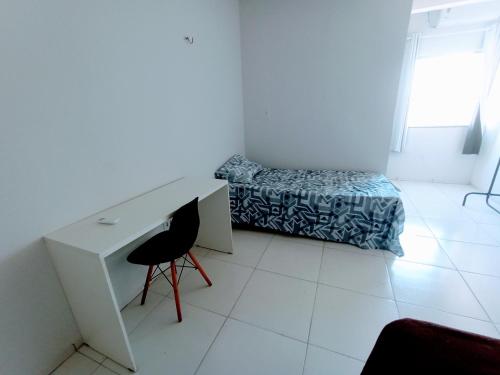 um quarto branco com uma secretária e uma cama em Apartamento Mobiliado no Centro da Cidade em Imperatriz