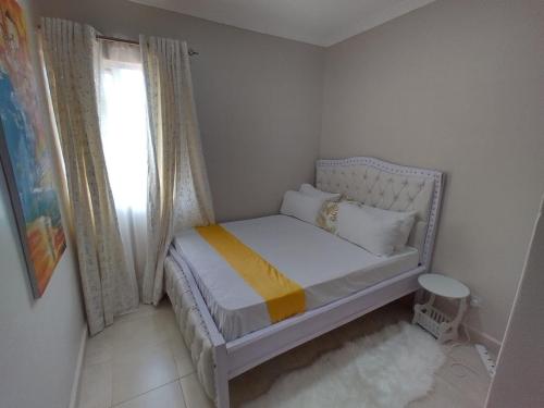 a small bedroom with a bed and a window at Kathy's Two Bedrooms in Nairobi